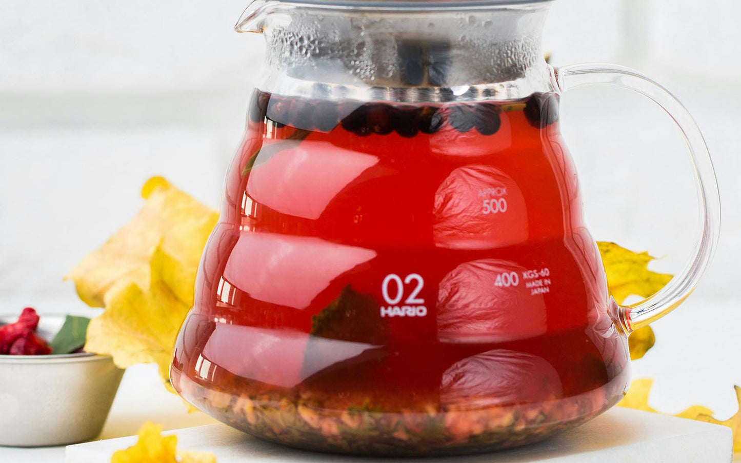 Tea pot with red berry tea and '02' label on a white background