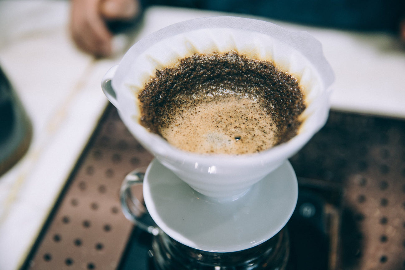 V60 pour over coffee, over a large glass jar.